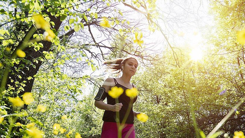 Spirituelles Laufen Eine Frau joggt durch die blühende Natur