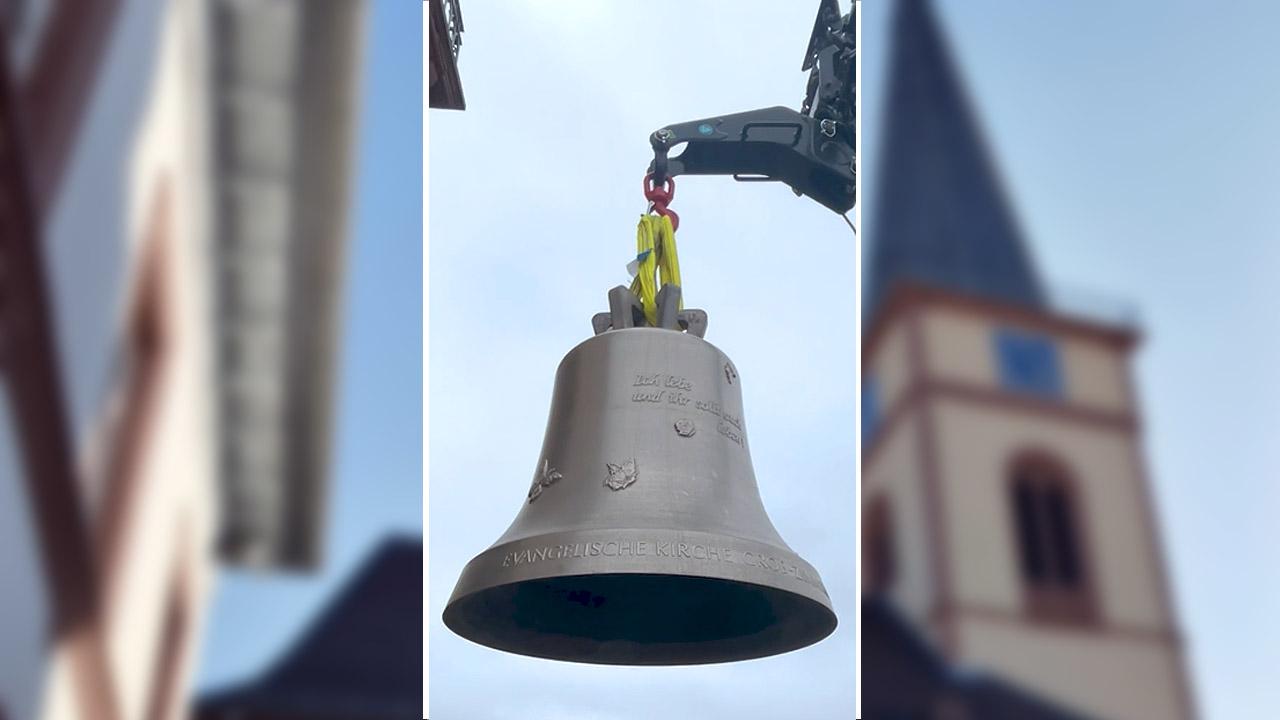 Im Hintergrund die Kirche von Groß-Zimmern, im Vordergrund eine der neuen Glocken