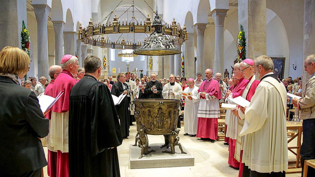 Pfarrer verschiedener Kirchen mit violetten, weißen und schwarzen Talaren bei einer ökumenischen Tauffeier im Hildesheimer Dom 
