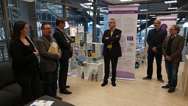 Personengruppe vor Infotafel