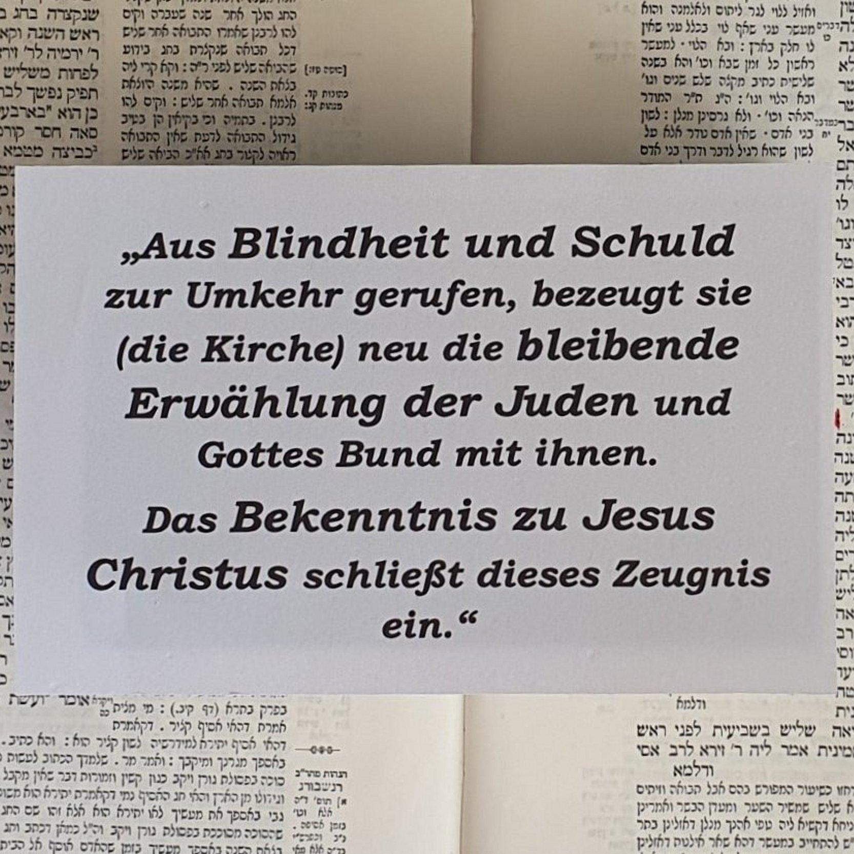 Zu sehen ist der Abschnitt aus dem Grundartikel der EKHN. Im Hintergrund eine Seite aus dem Babylonischen Talmud.