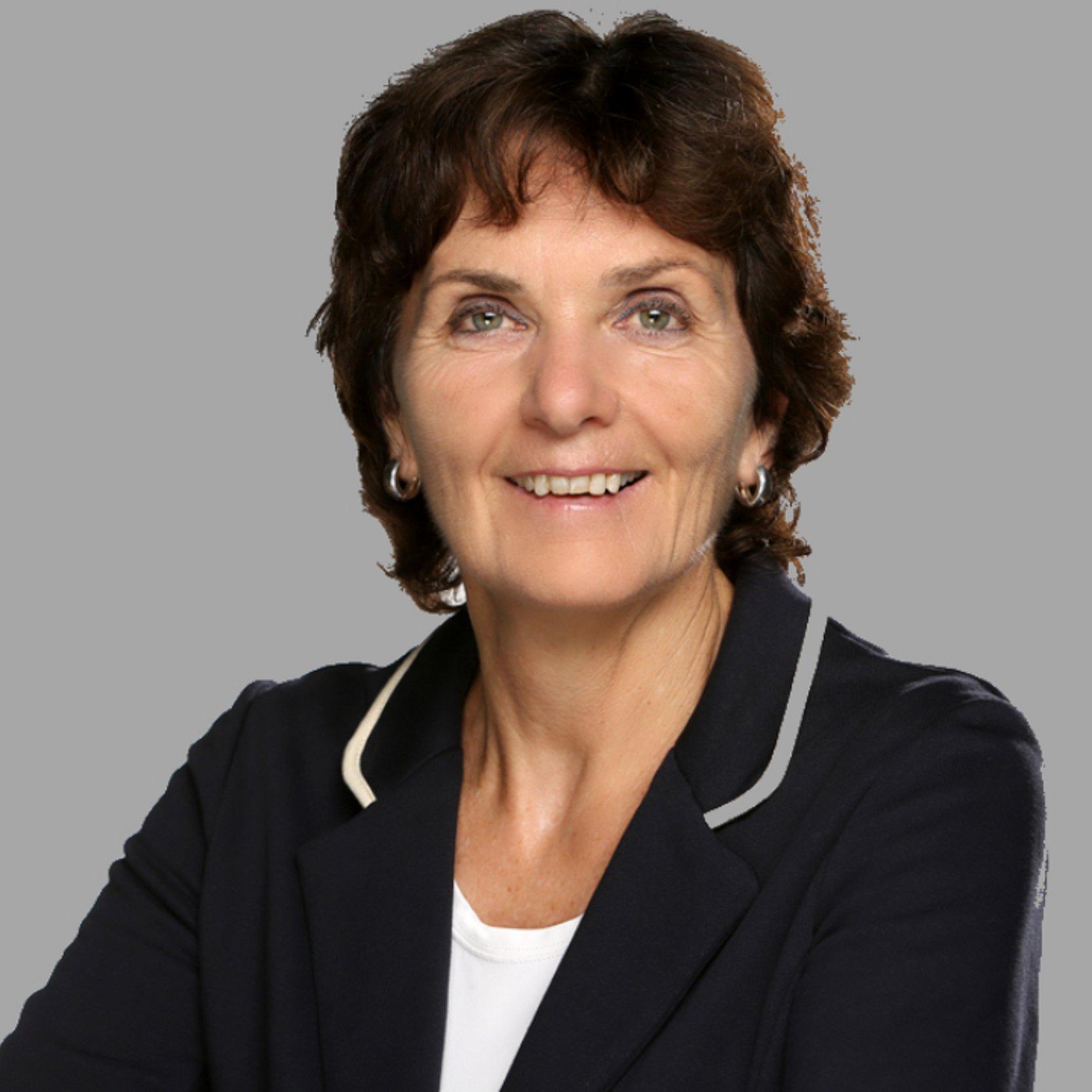 Frauenpfarrerin Helga Engler-Heidle blickt in die Kamera, sie hat dunkle kurze Haare und trägt eine blaue Jacke
