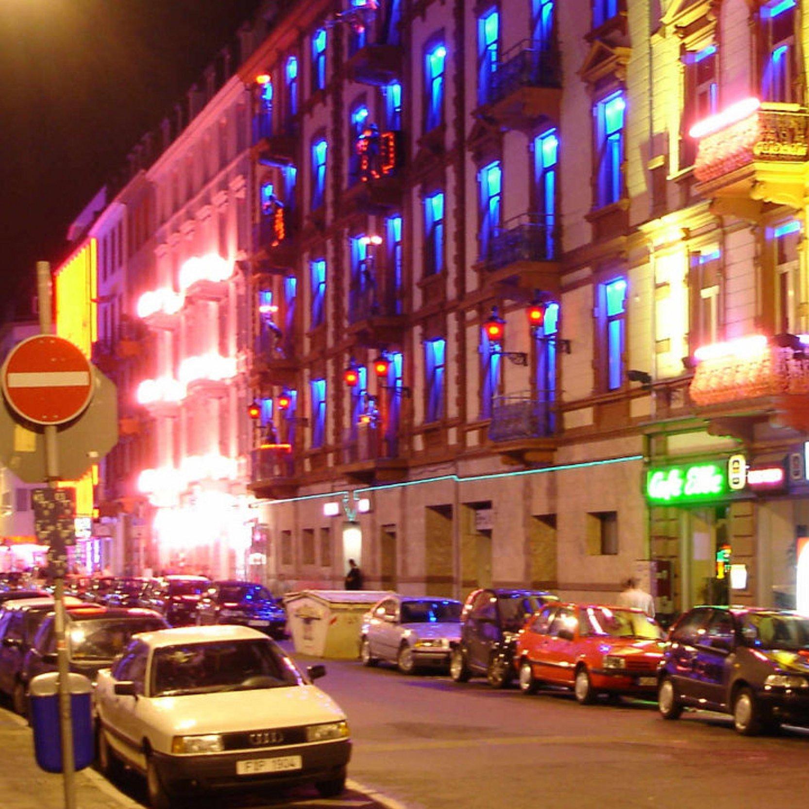Straße in Frankfurt bei Nach, bunte Lichter von den Fenstern, rote Herzen, es ist das Rotlichtviertel
