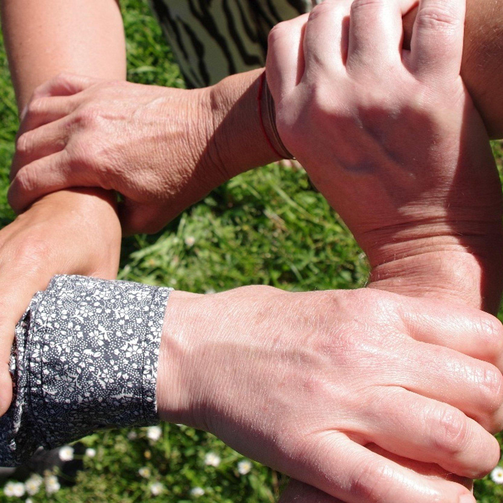 Vier verschränkte Hände