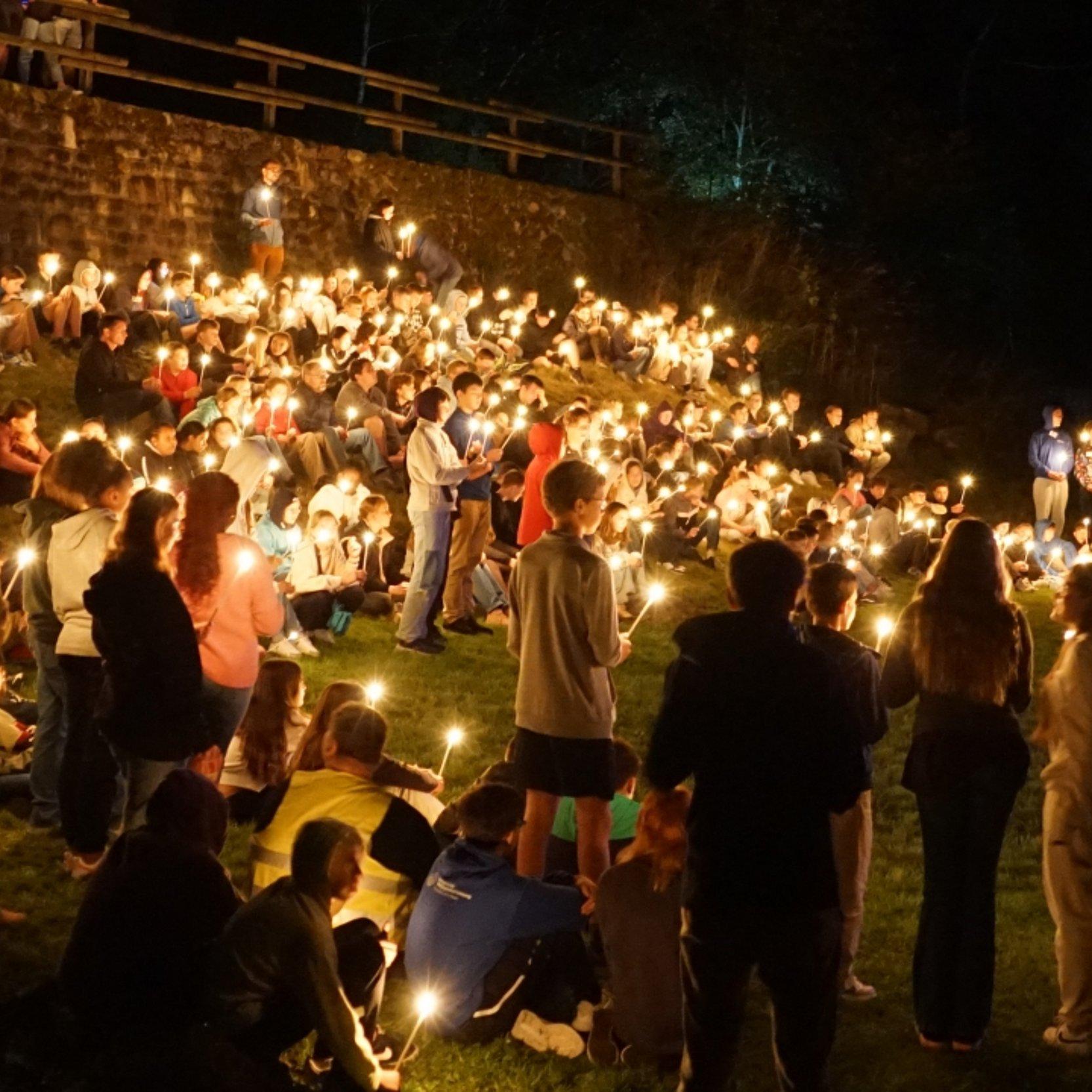 Viele Jugendliche mit Kerzenlicht in der Nacht
