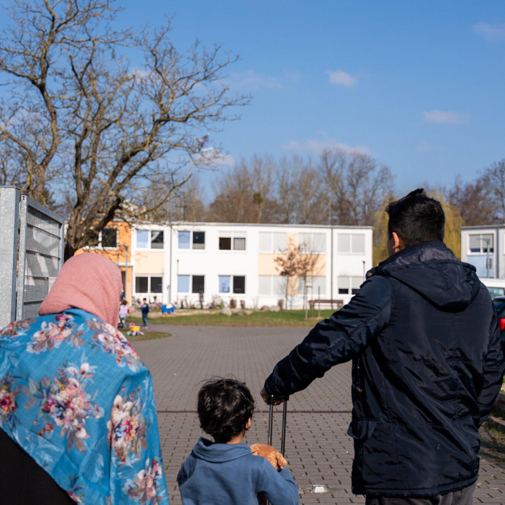 Vater, Mutter und Kind kommen in einer Unterkunft an