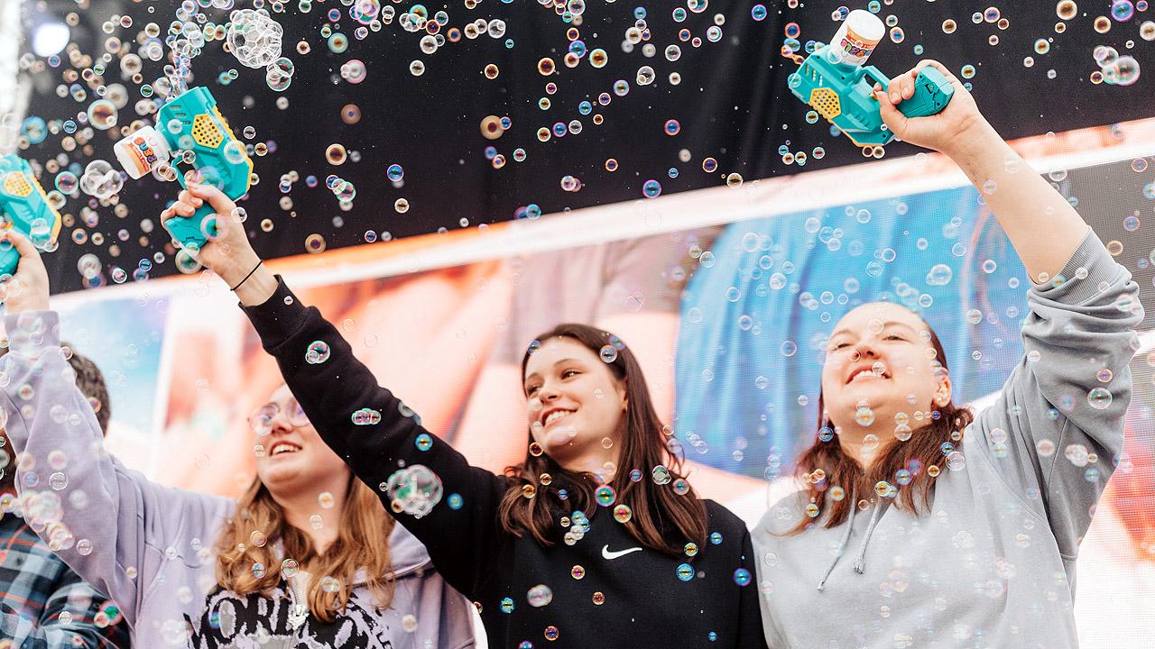 Drei Mädchen auf der Bühne schießen Seifenblasen in die Luft