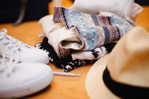 Turnschuhe, Stoffe und ein Hut auf einem Tisch