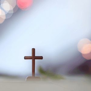 ein Kreuz vor einem hellen Hintergrund mit Lichtreflexen