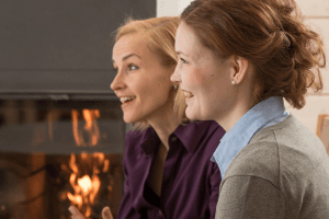 Zwei Frauen, die ihren Blick nach links gewendet haben und lachen.