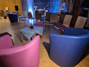 Sessel, Sofa und Stühle in einer Runde vor dem Altar