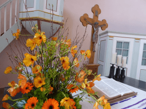 Blick auf den Altar mit Blumenstrauß und Kreuz