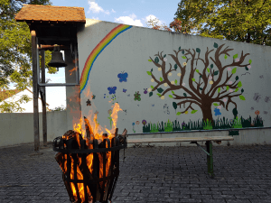 Feuerkorb mit brennenden Holzscheiten im Atrium des Gemeindezentrums