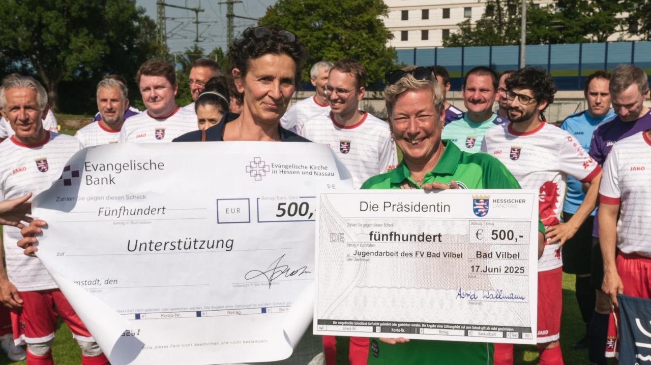 Scheckübergabe Benefizspiel Hessentag 2025 Pröpstin AnkeAnke Spory und Claudia Türk vom FV Bad Vilbel e.V. halten übergroße Spendenschecks hoch.