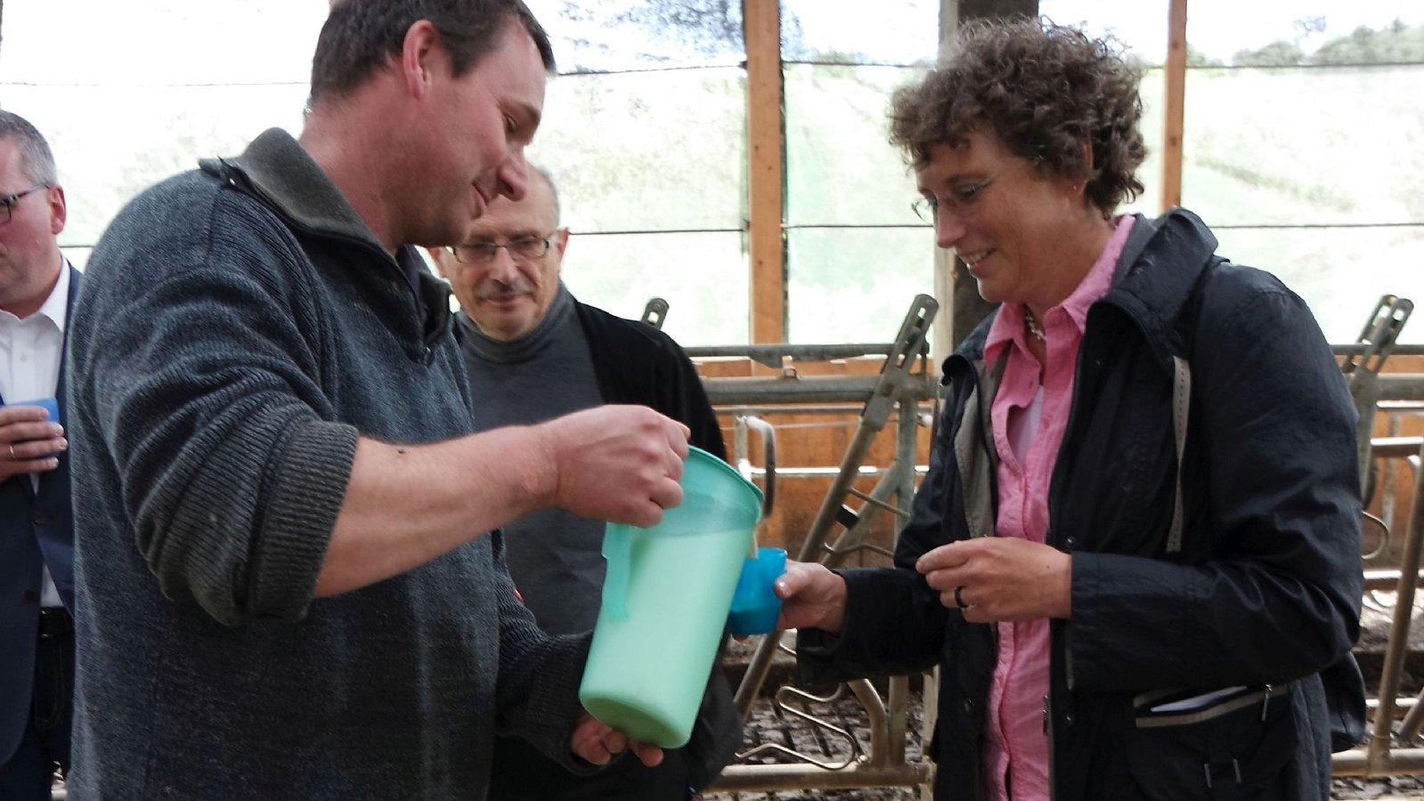 Milch beim Bauern Bottenhorn Bauer im Stall schenk ein Glas Milch ein.