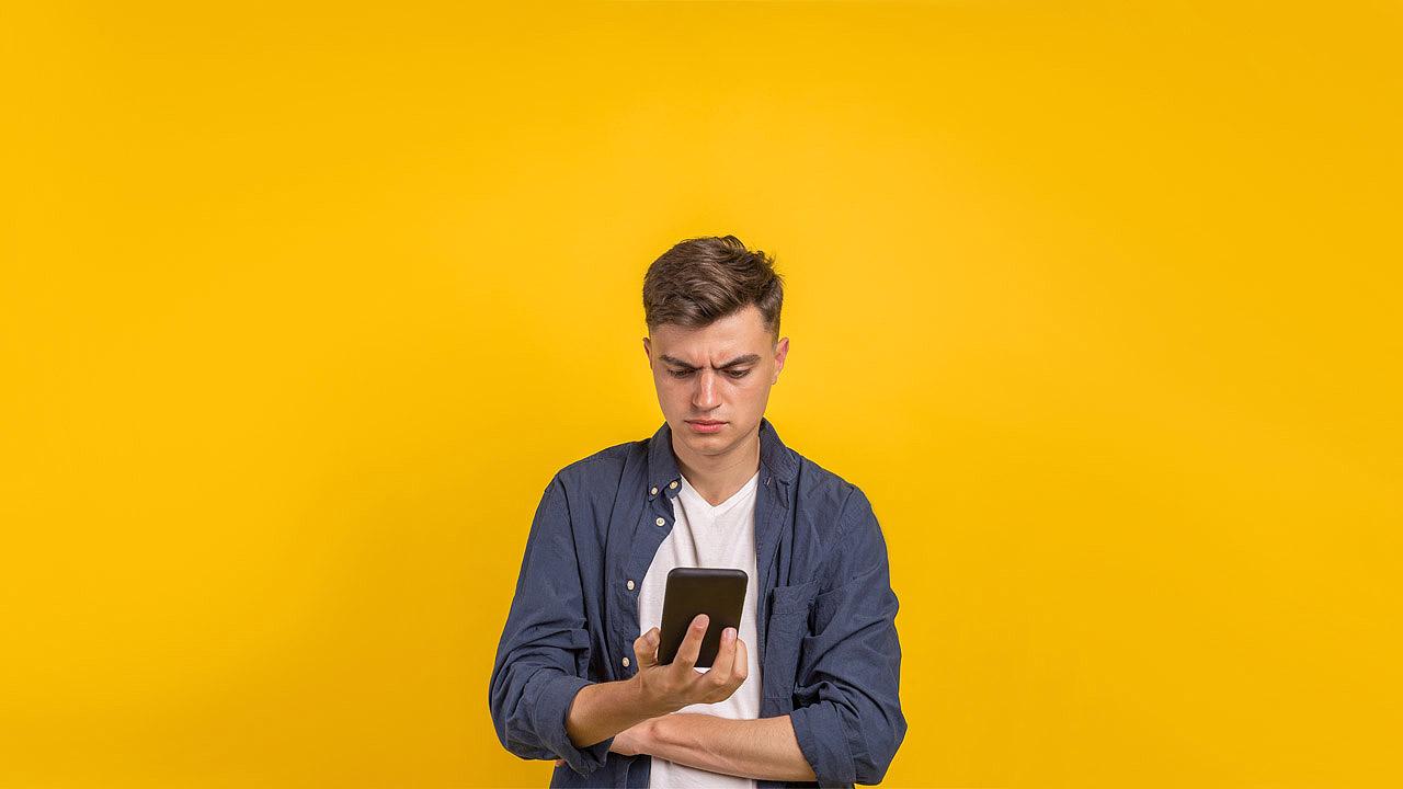 Nachrichten checken Ein junger Mann checkt die Nachrichten auf seinem Smartphone