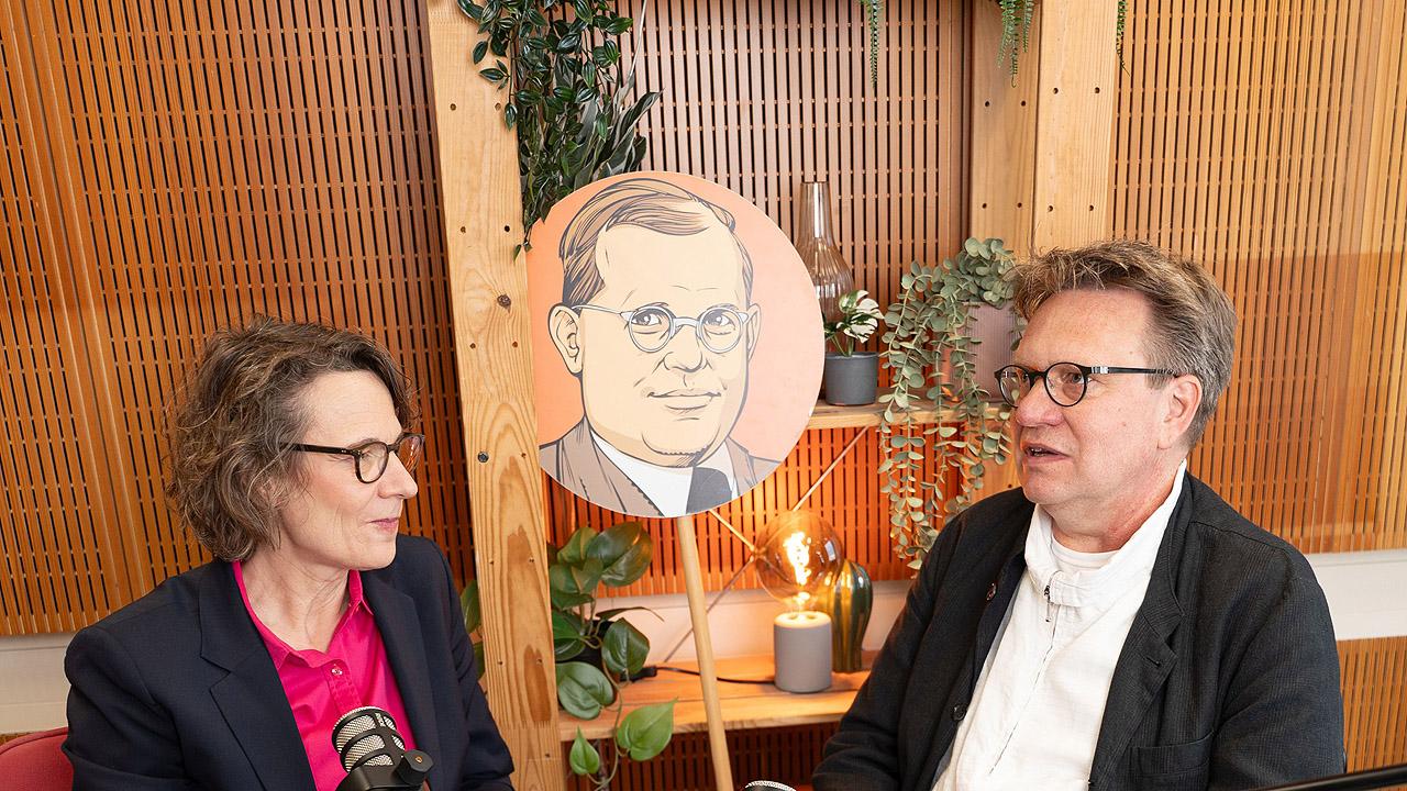 Dietrich Bonhoeffer Bonnhoeffer-Grafik auf einem Schild in der Mitte, daneben Christiane Tietz und Frank Muchlinsky