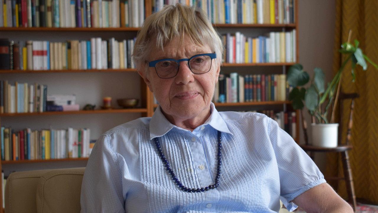 Ursula Hauptmann Ursula Hauptmann sitzt mit einer hellblauen Bluse und einer dunkelblauen Kette in ihrem Wohnzimmer, im Hintergrund ist ein Bücherregal