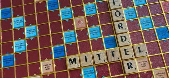 Mit Scrabble-Steinen gelegte Wörter Förder und Mittel