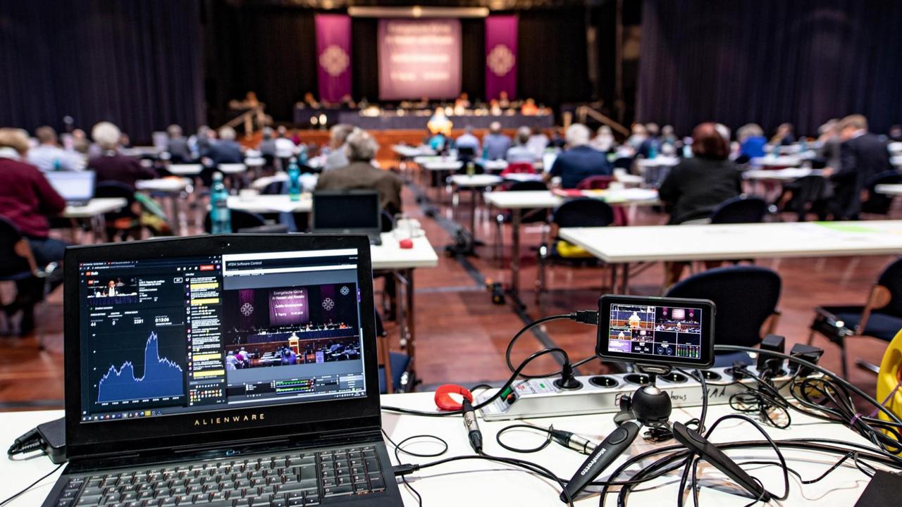 großer Raum der Kirchensyode, Ein aufgeklappt Laptop im Vordergrund, daneben Aufzeichnungstechnik