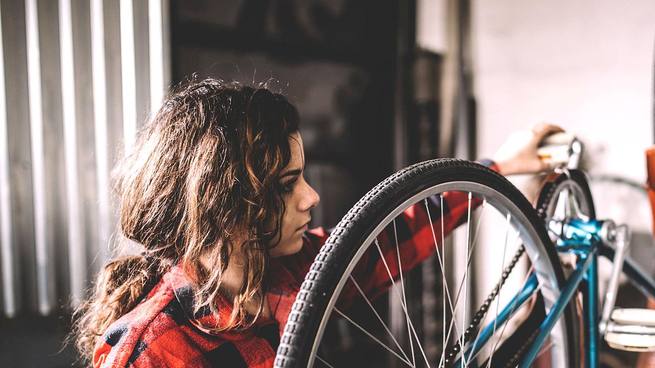 Jugendwerkstatt Gießen Eine junge Frau repariert ein Fahhrad