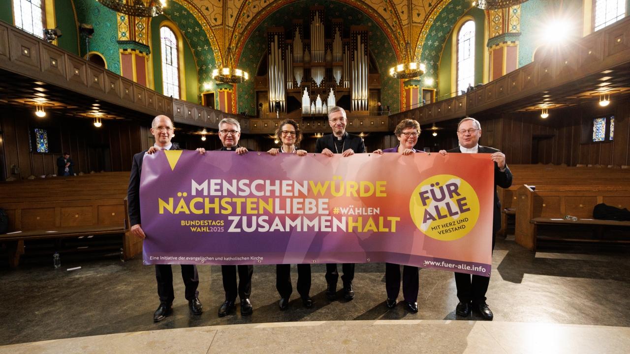 Gemensame Aktion zur Bundestagswahl Gruppenbild, die Kirchenleitenden halten ein großes Banner vor sich.