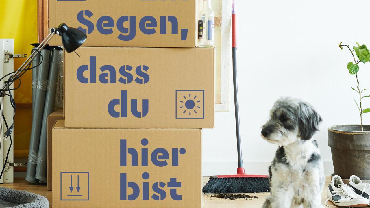 Willkommen am Wohnort Umzugskartons mit Aufschrift: Ein Segen, dass du hier bist