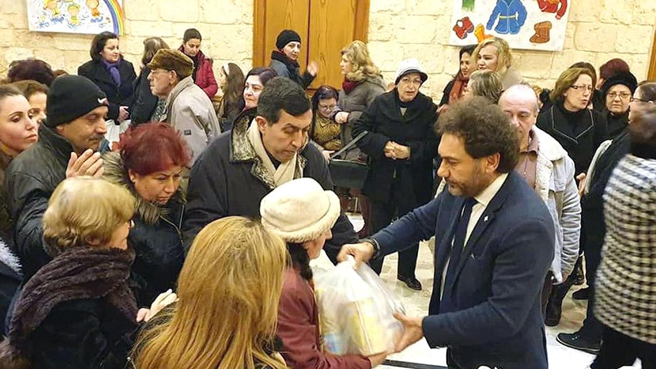 Lebensmittelspenden Ein Mann überreicht eine Tüte an andere Menschen