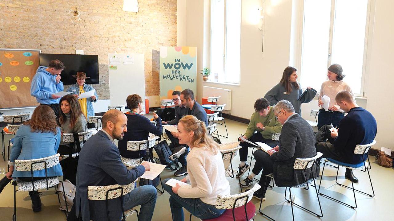 M Menschen sitzen bei einem Workshop zusammen