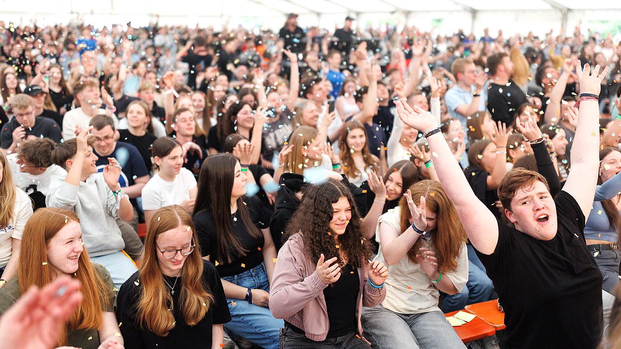 Jugendkirchentag Jubelnde Jugendliche, darüber riesendes Konfetti