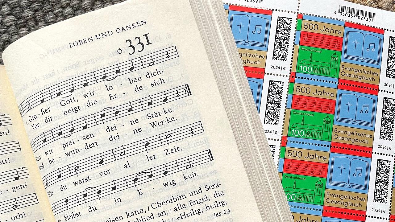Gesangbuch und Briefmarke Gesangbuch neben Briefmarken