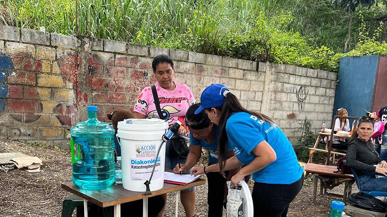 Wasseraufbereitung Menschen mit Kanistern und anderen Materialen beschäftigen sich mit Wasseraufbereitung