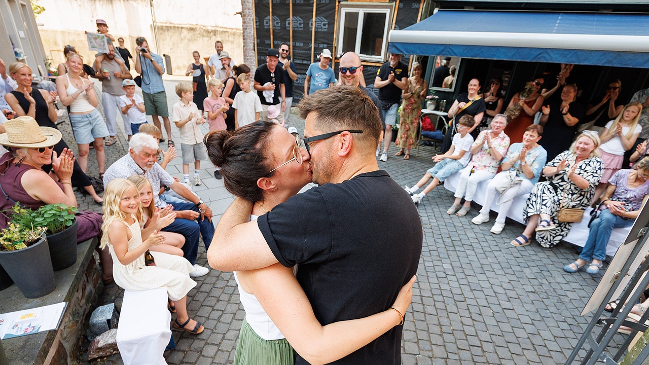 einfach heiraten Ein Paar küsst sich, andere applaudieren