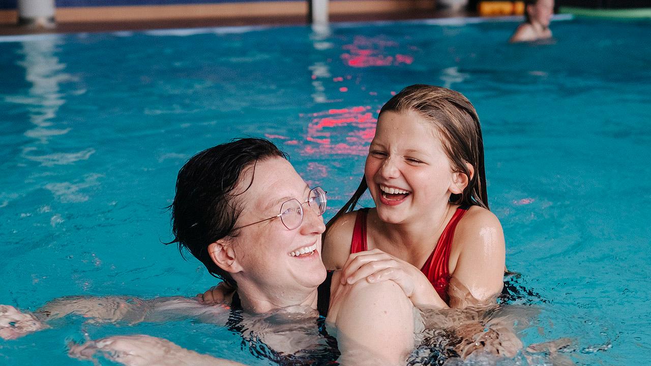 Mutter-Kind-Kur Eine Frau schwimmt mit einem Kind im Schwimmbad