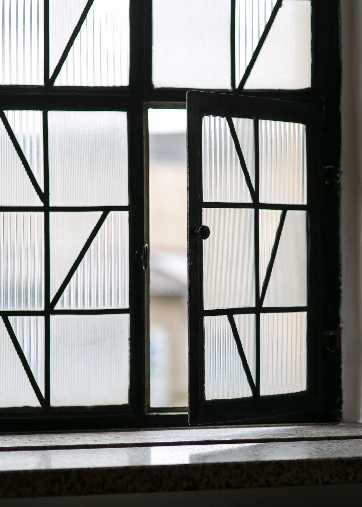 offenes Fenster Fenserfront aus Reliefglas. Ein Teilfenster davon ist geöffnet