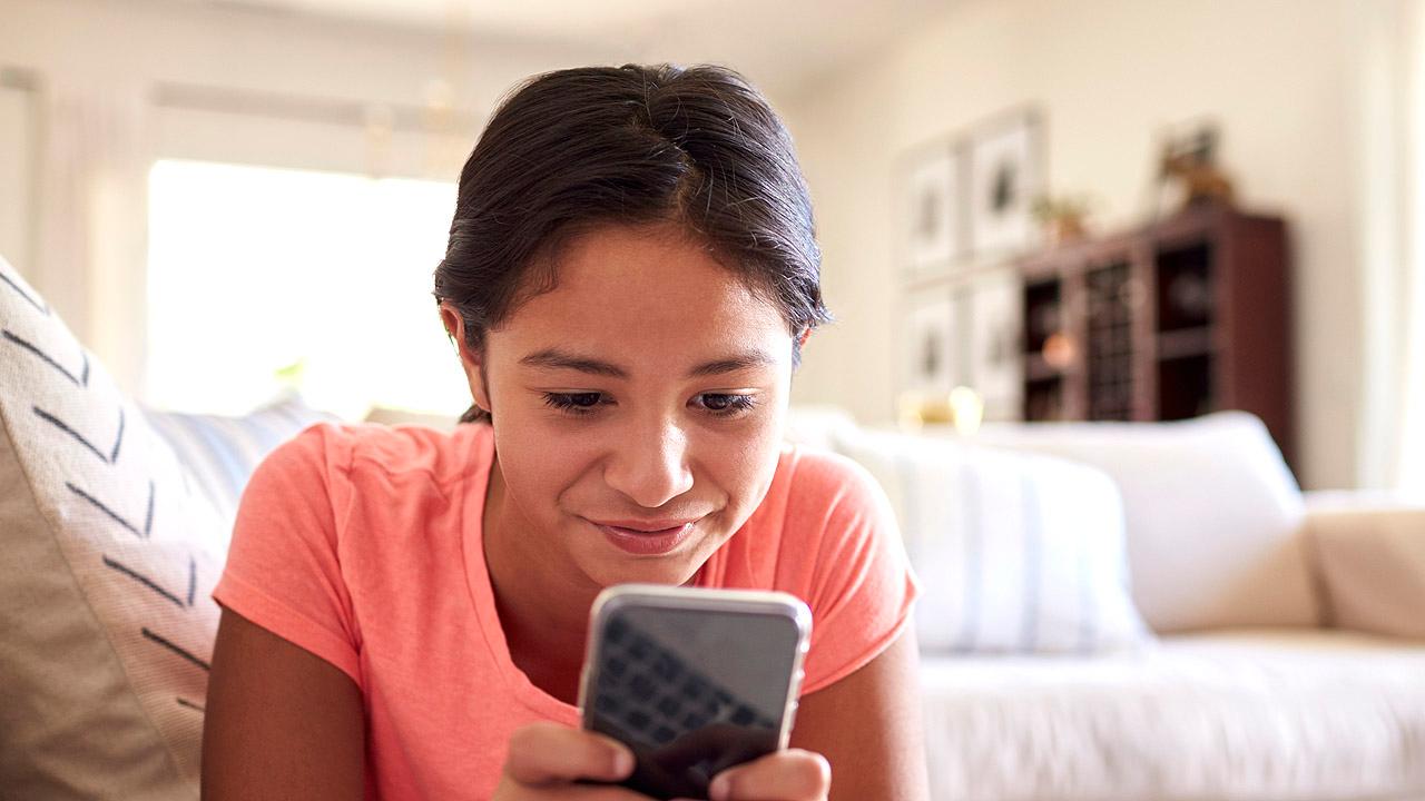 Jugendliche Ein Mädchen schaut in ein Smartphone