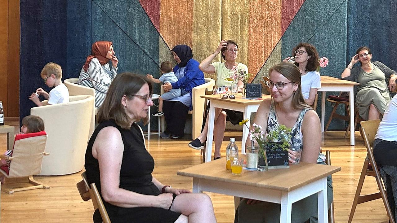 Cafédrale Menschen, die an Tischen sitzen in einem Kirchenraum, der mit Holz ausgekleidet ist