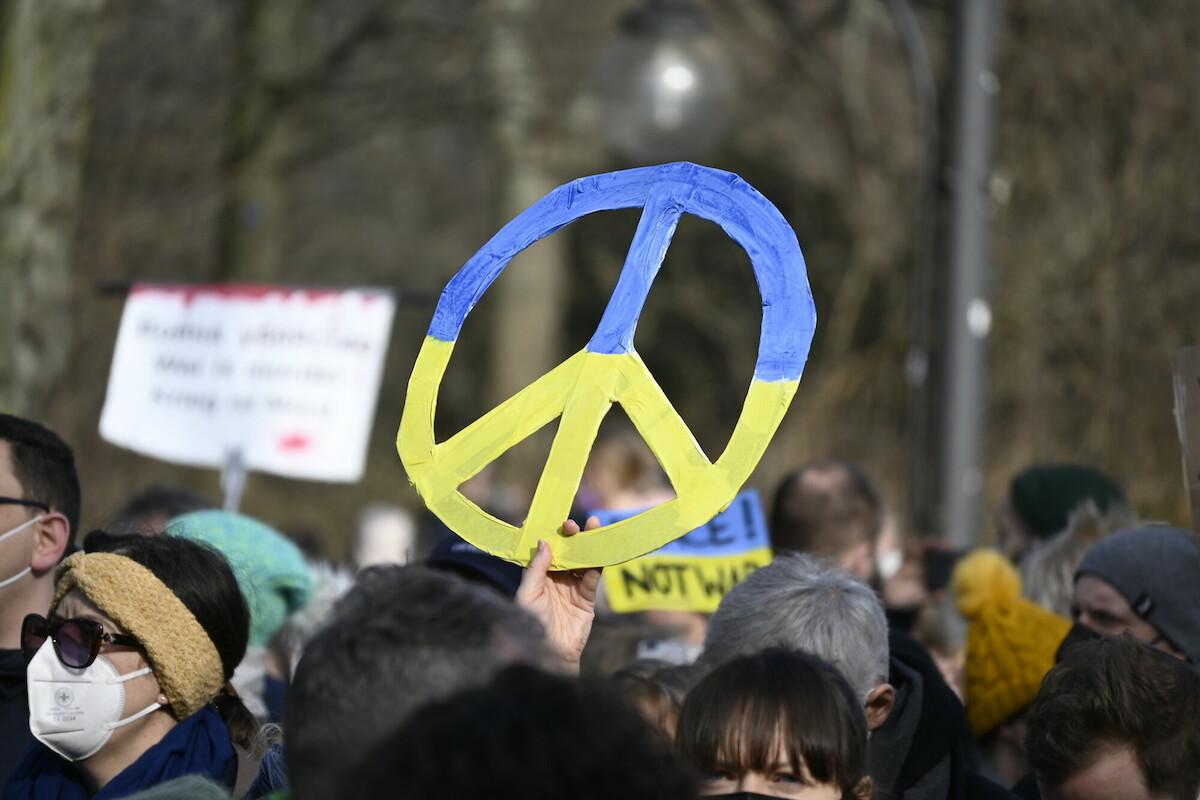 Ein buntes Friedenszeichen wird bei einer Demonstration für Frieden in der Ukraine hochgehalten.