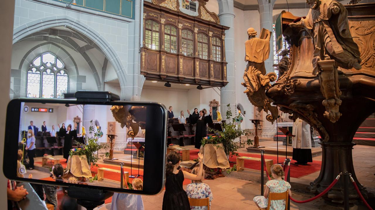 Kircheninneres, Kinder, ein Bildschirm im Vordergrund