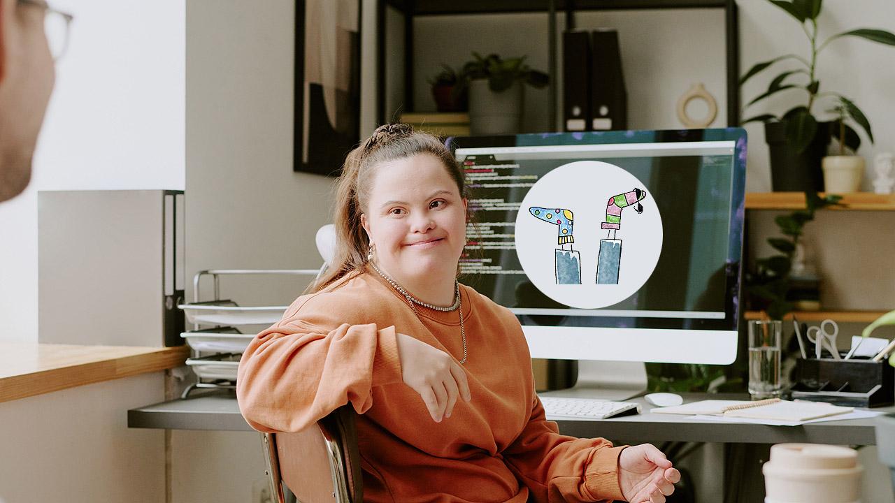 Eine junge Frau mit Trisomie 21 sitzt am Computer