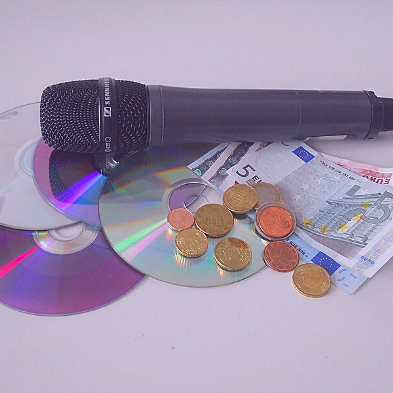 3 CDs, 1 Mikro und Bargeld liegen auf einem Tisch