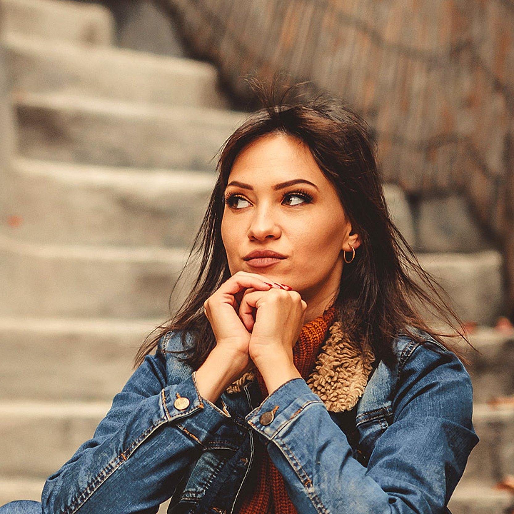Auszeit im Kloster Eine Frau betet auf einer Treppe eines alten Gebäudes