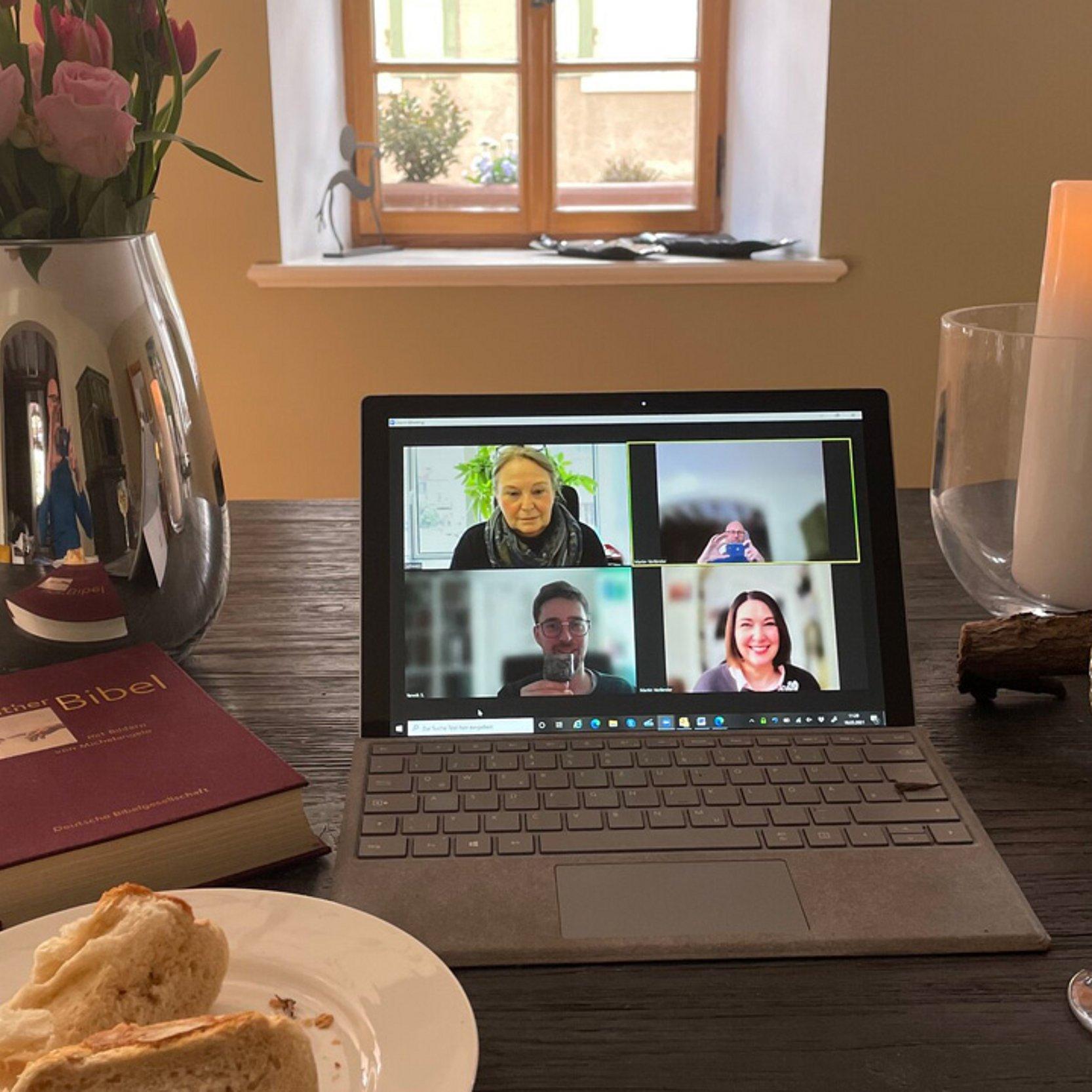 Digitales Abendmahl Altar mit Kerzen, Brot und Wein oder Saft, in der Mitte ein aufgeklappter Laptop