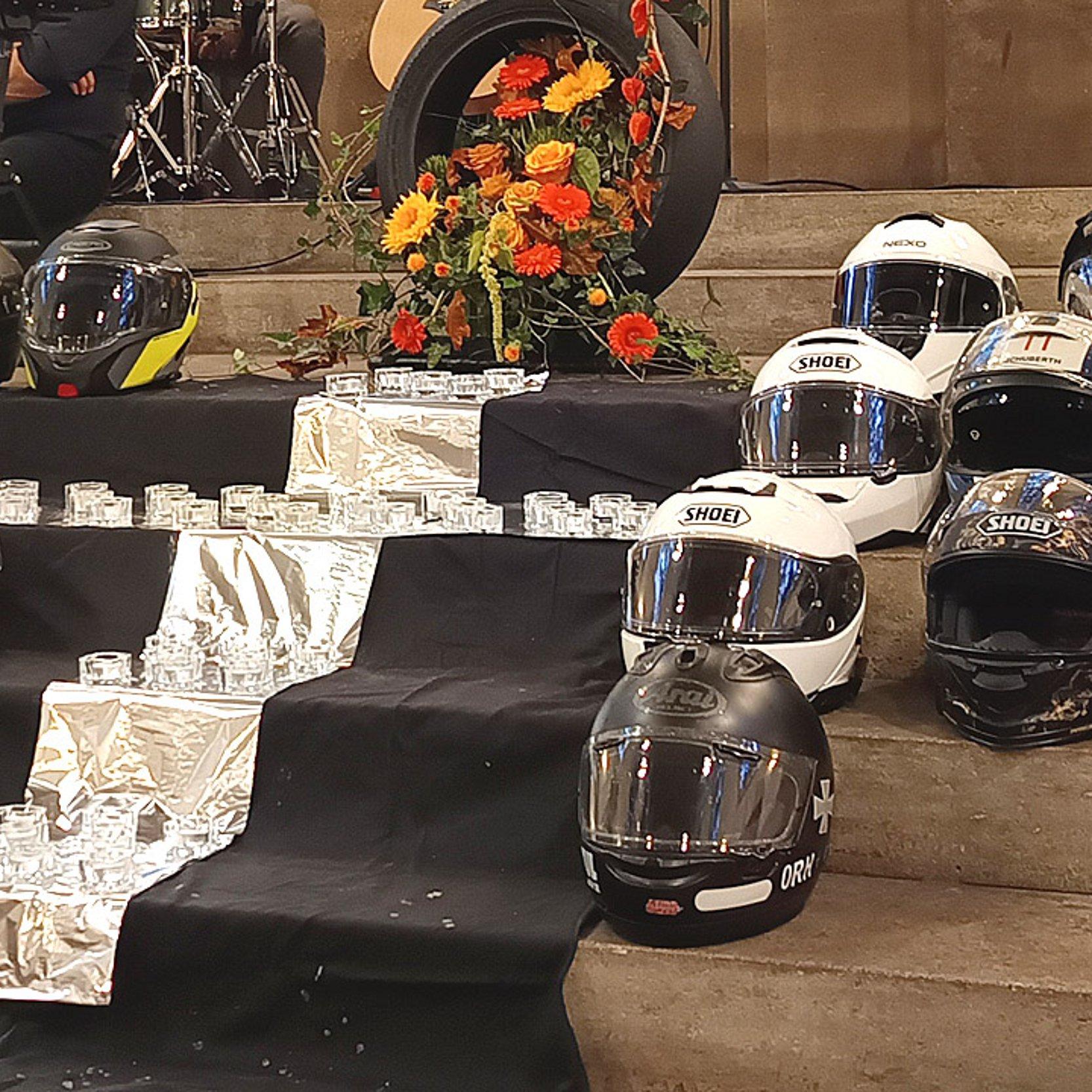 Gedenken an verunglückte Motorradfahrerinnen und Motorradfahrer Kreuz aus Teelichtern gelegt, daneben die Motorradhelme der verstorbenen Motorradfahrer
