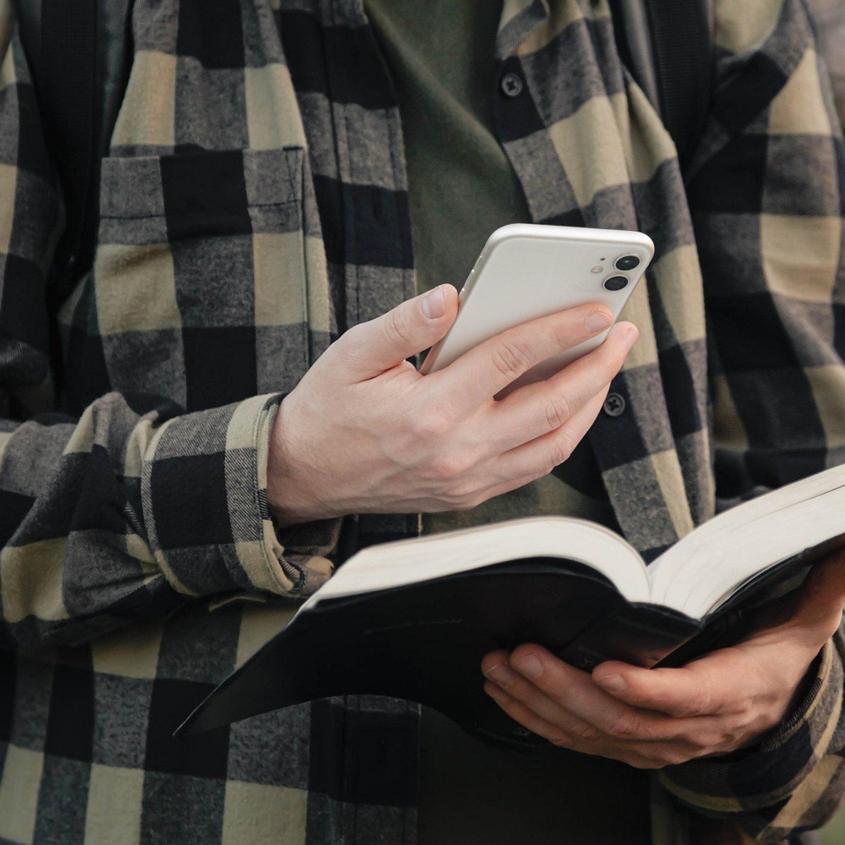 Fortbildgung für Pfarrer:innen Mann mit Handy und Bibel.