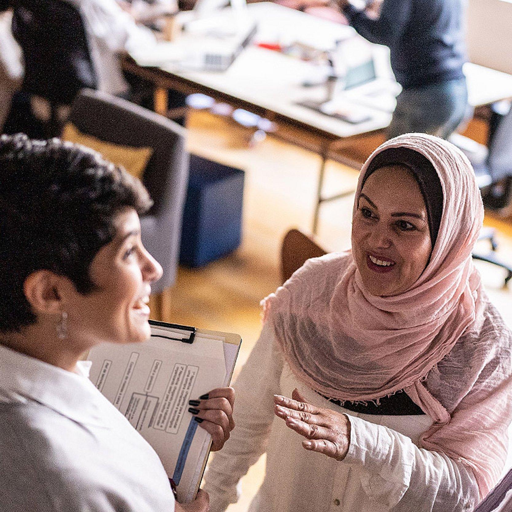 Muslimin und Frauen anderen Glaubens im Gespräch Eine Frau mit Kopftuch spricht mit anderen Frauen, die kein Kopftuch tragen