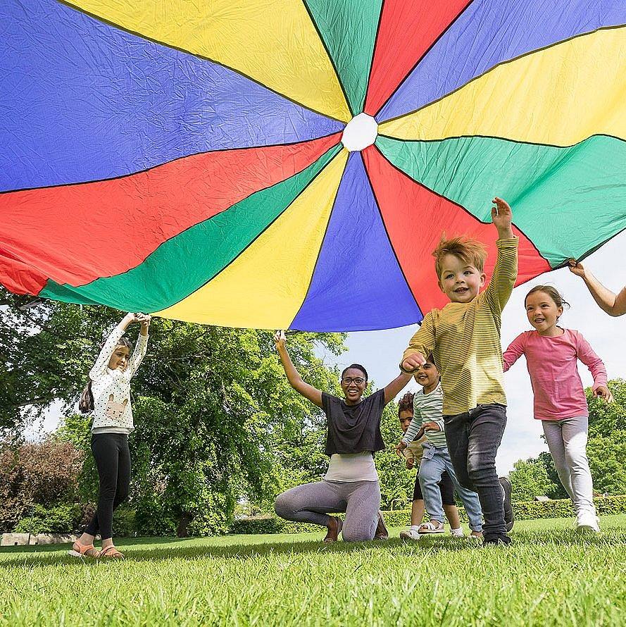 Kinder laufen unter buntem Tuch durch