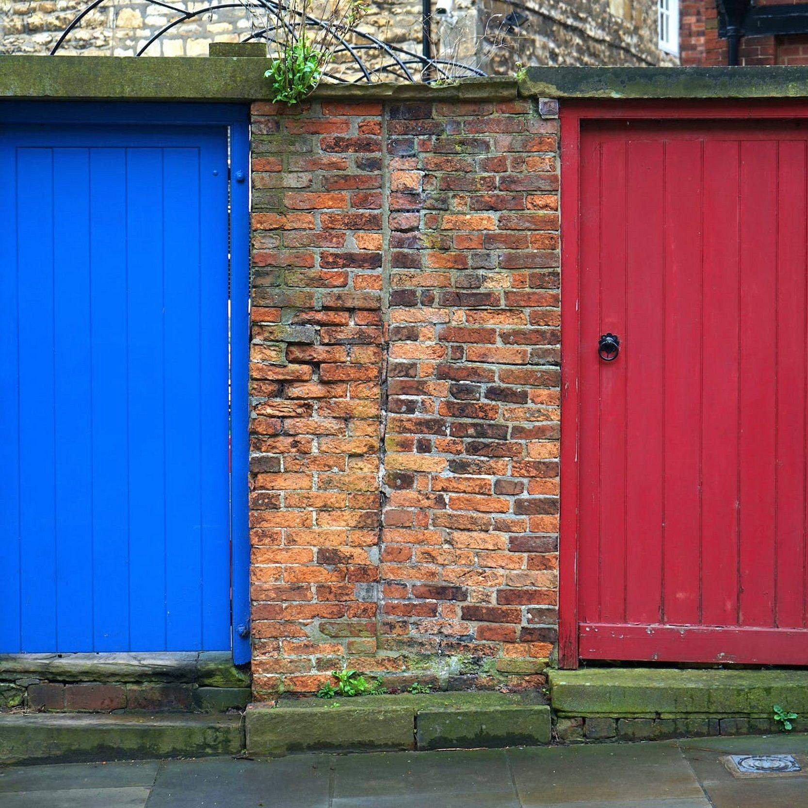 Mauer mit zwei Türen, eine blau, die andere in rot