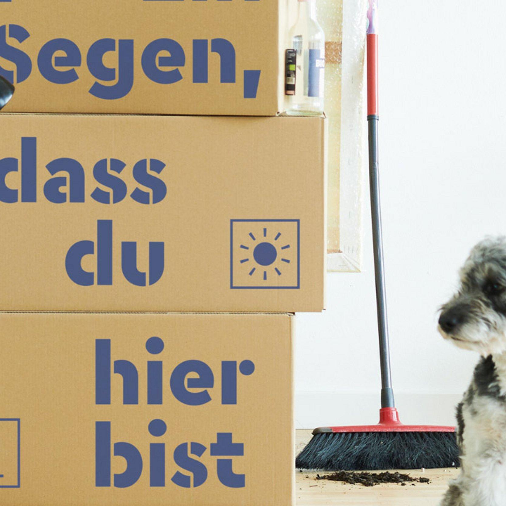 Willkommen am Wohnort Umzugskartons mit Aufschrift: Ein Segen, dass du hier bist
