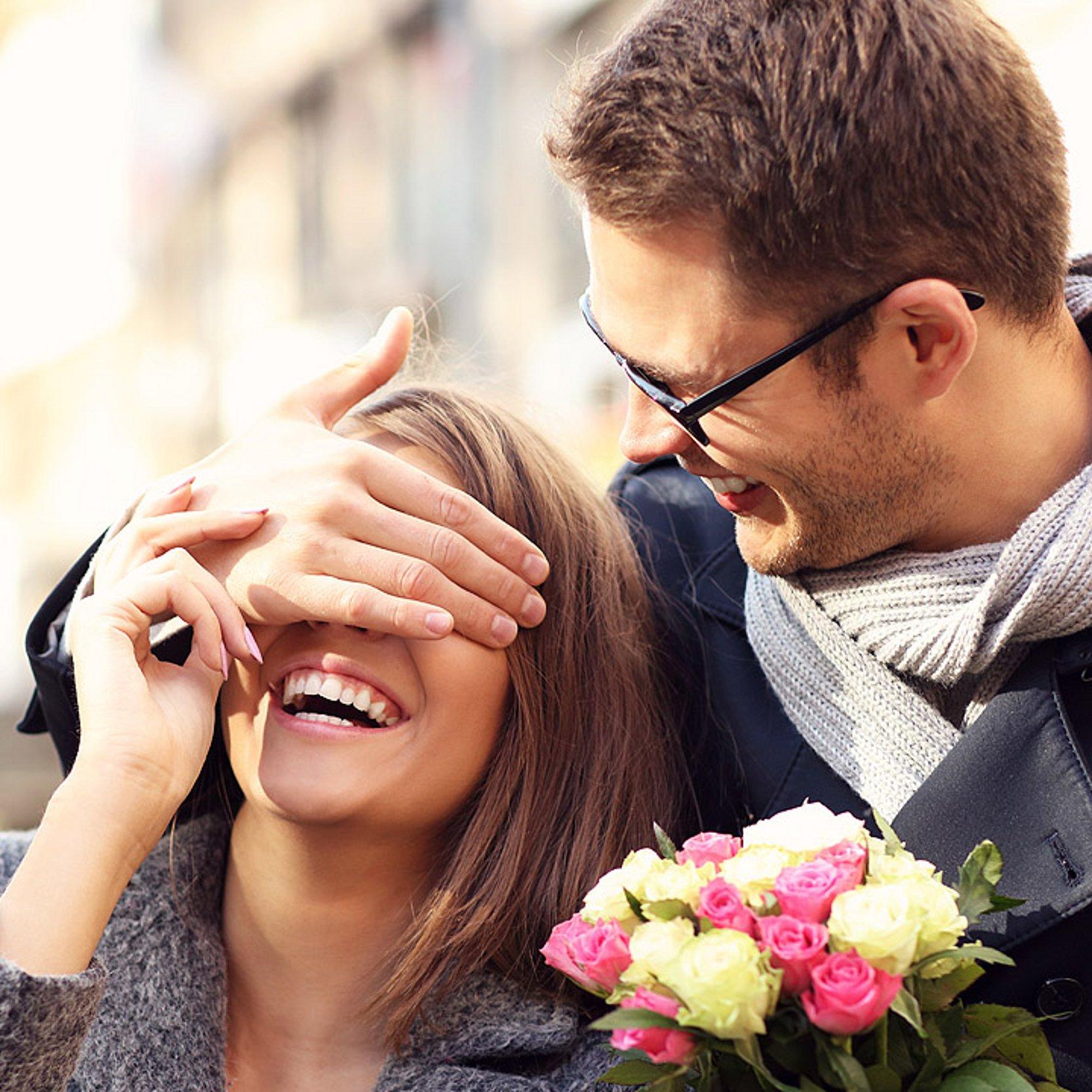 Paar auf dem Weg zur Segnung Mann hält einer Frau die Augen zu und will sie überraschen